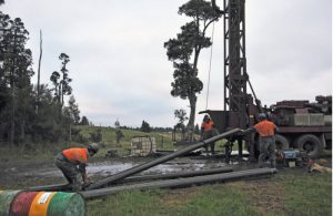 Drilling crewman prepare to lift pre-collar pipe into position on a rig drilling for coal seam gas